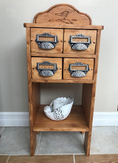 a wooden cabinet with drawers and knobs on the bottom shelf next to a tile floor