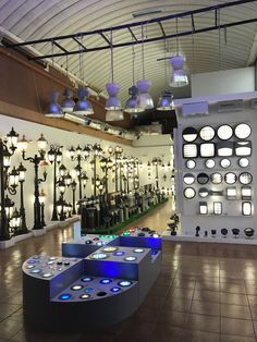 a room filled with lots of lamps and lights on the ceiling above them is a display case