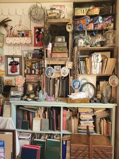 a book shelf filled with lots of books next to a wall covered in pictures and knick knacks