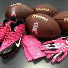 pink and black footballs, mitts, gloves and glove are on the table