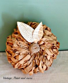 a close up of a paper ball with leaves on it and words written in the middle