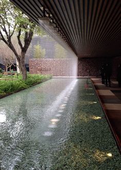 the water is running down the side of the building with people walking around in it