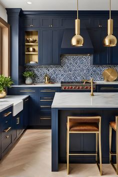 a kitchen with blue cabinets and gold pendant lights hanging from the ceiling over the island