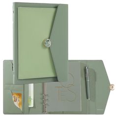 a green binder with a note book and pen