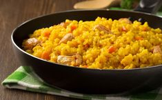 a pan filled with rice on top of a wooden table