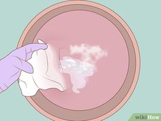 a hand holding a cloth in front of a pink bowl with steam coming out of it