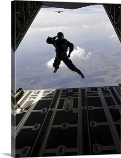 a man is in the air with his feet up and arms out as he jumps from an airplane