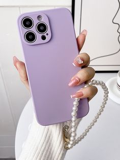 a woman's hand holding a purple phone case with two buttons on the back