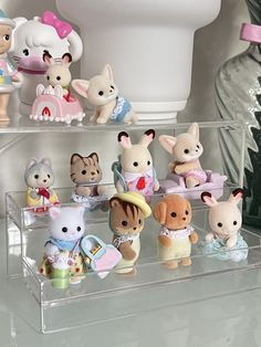 there are many small toy animals on the shelf