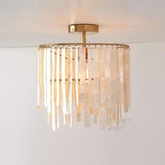 a chandelier hanging from the ceiling in a room with white walls and flooring