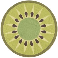 a green rug with black and brown designs on the center, in front of a white background