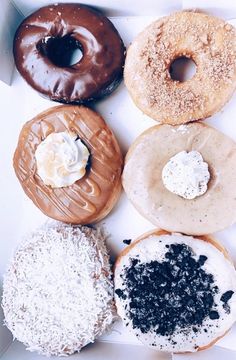 six donuts with different toppings in a box