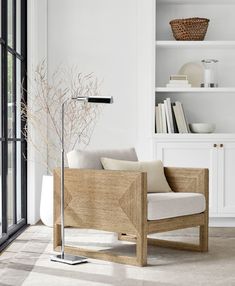 a living room filled with furniture and a tall lamp on top of a wooden floor