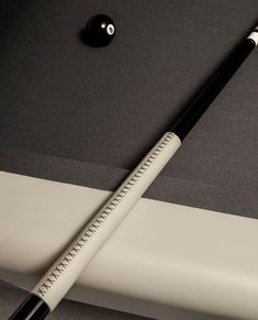 a black and white pool cue laying on top of a table