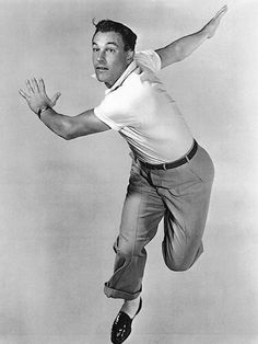 a black and white photo of a man jumping in the air