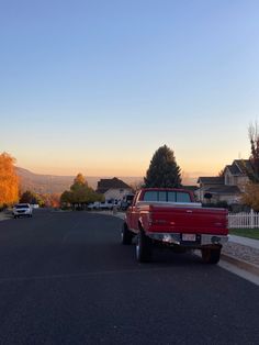 a red truck parked on the side of a road