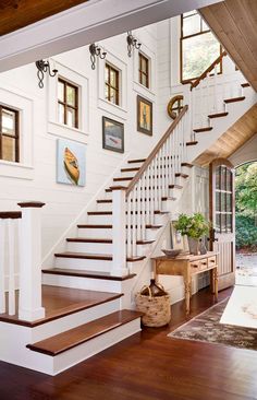 there is a staircase in the house with pictures on the wall and wood flooring