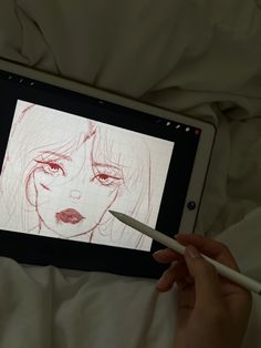 a person is drawing on an ipad with a pencil in their hand while laying down