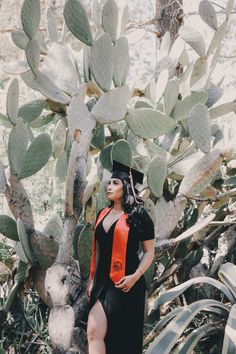 a woman standing in front of a cactus tree