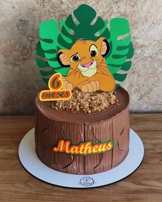 a birthday cake with a lion on top and leaves in the shape of a tree stump