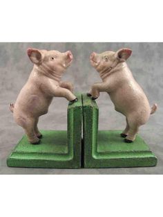 two little pigs playing with each other on green blocks