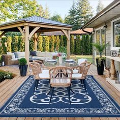 an outdoor dining area with chairs, table and umbrella