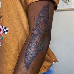 a close up of a person with a butterfly tattoo on his arm and the other arm