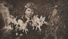 an old photo of a woman with flowers in her hair