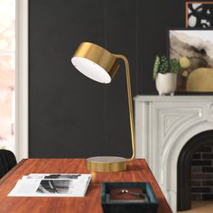 a desk lamp sitting on top of a wooden table in front of a fire place