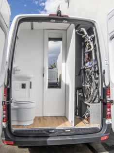 the back door of a van is open to show bikes in it's storage compartment