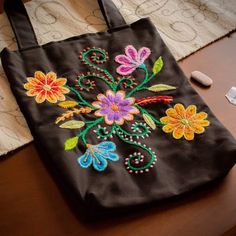 an embroidered bag sitting on top of a wooden table