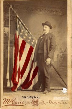 an old time photo of a man in uniform holding the american flag