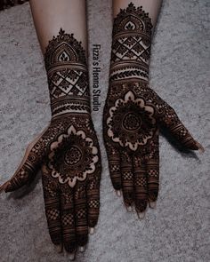 two hands with henna designs on them