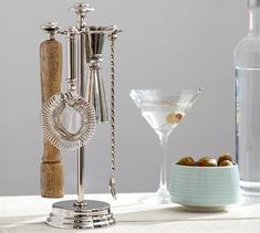 an assortment of wine accessories on a table next to a martini glass and bottle opener