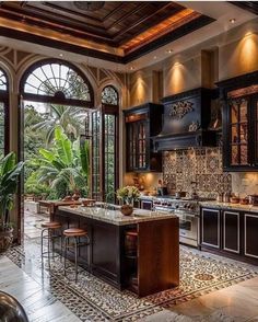 a large kitchen with an island in the middle of it and lots of windows to let in natural light