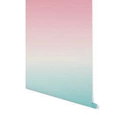 a pink and blue ombreed wall hanging on the side of a white wall