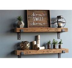 two wooden shelves with plants and other items on them, one shelf has a sign that says home sweet home