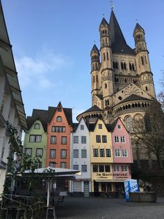 several different colored buildings in front of a church