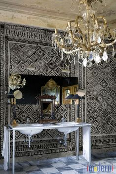 an ornately decorated room with chandelier, mirror and table in the center