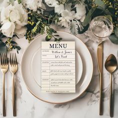 a table setting with place cards, silverware and flowers