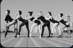 a group of women in black leotards posing for the camera with their hands on their hips