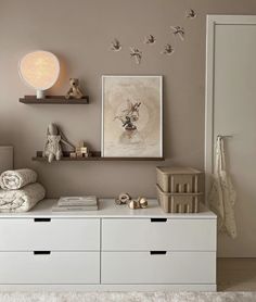 a white dresser sitting in a bedroom next to a wall filled with pictures and toys