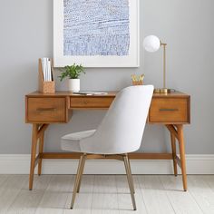 a white chair sits in front of a desk with a painting on the wall behind it