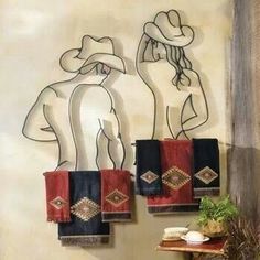 towels are hanging on the wall in front of a towel rack with two women's silhouettes