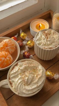 three desserts on a wooden tray with candles and candies next to each other