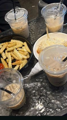 some food is sitting on a table with plastic cups and spoons next to it