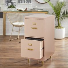 a white filing cabinet sitting on top of a hard wood floor next to a chair