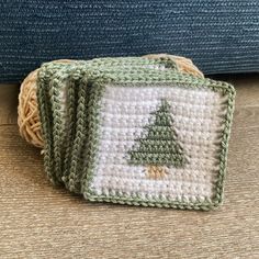 three crocheted coasters with a small christmas tree on one side and a smaller green square on the other