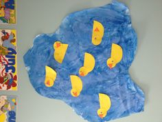 paper mache with yellow rubber ducks on blue background and children's books above