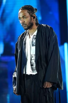 a man with dreadlocks standing on stage